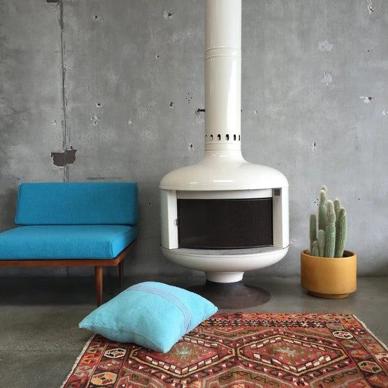 gorgeous looking Fireplace in a room beside a chair and a plant