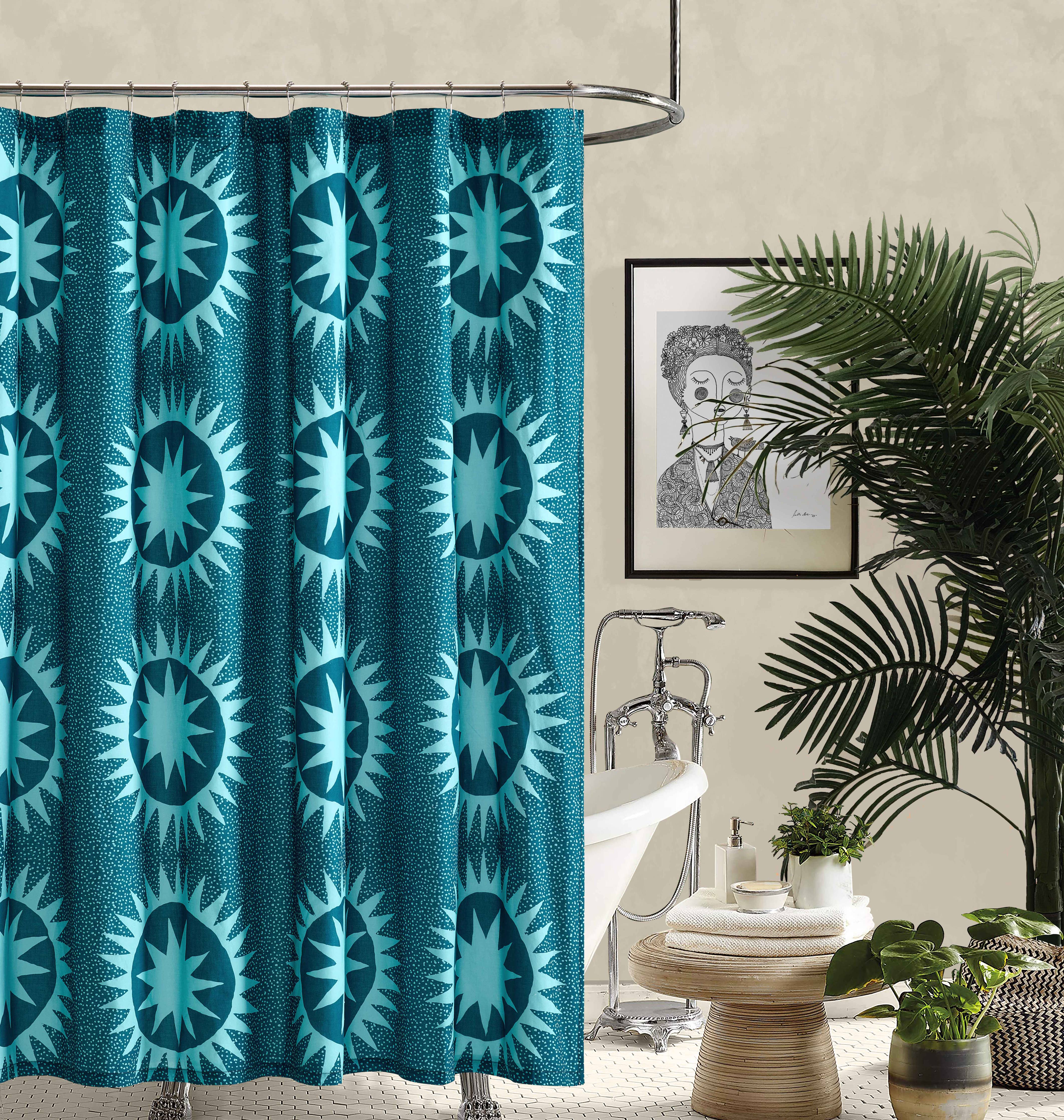 Teal patterned shower curtain in a bathroom with a bathtub and decor.