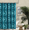 Teal patterned shower curtain in a bathroom with a bathtub and decor.