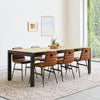 Black and Oak Dinint Table with six chairs on brown rug in room with white walls