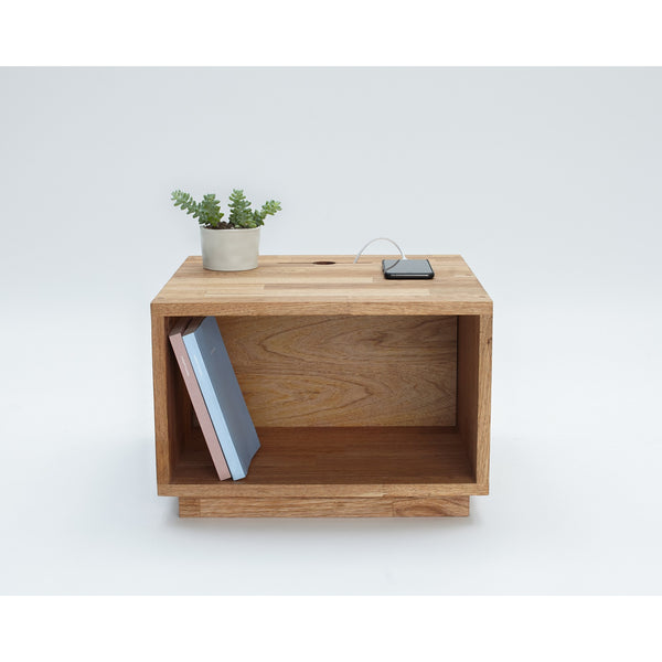 LAXseries Night Table with a book in storage, flower pot and plugged phone on top