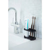 black toothbrush stand beside a faucet