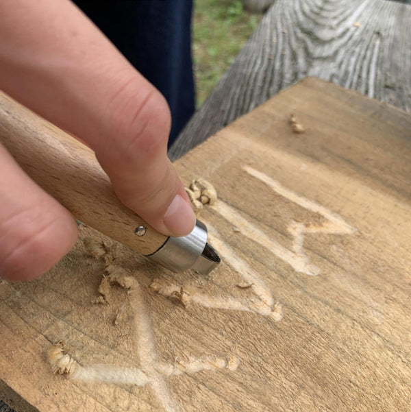 carving wood with name using a wood carving tool
